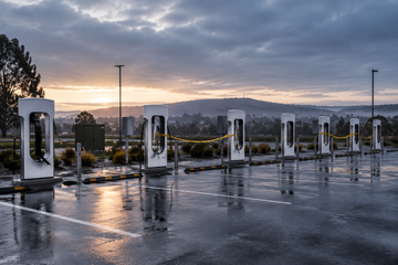 Row of Tesla Supercharger stalls with severed cables hanging down at a charging site in Ballarat, Australia.