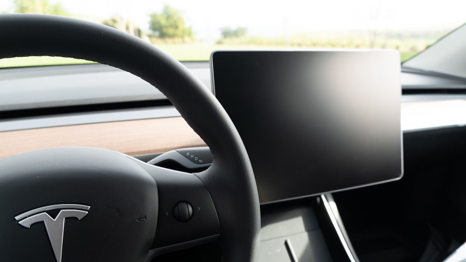 Steering wheel and dashboard of a car with a mounted device.