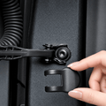 Hand positioning a black cover over the exposed check-arm mounting bolt.