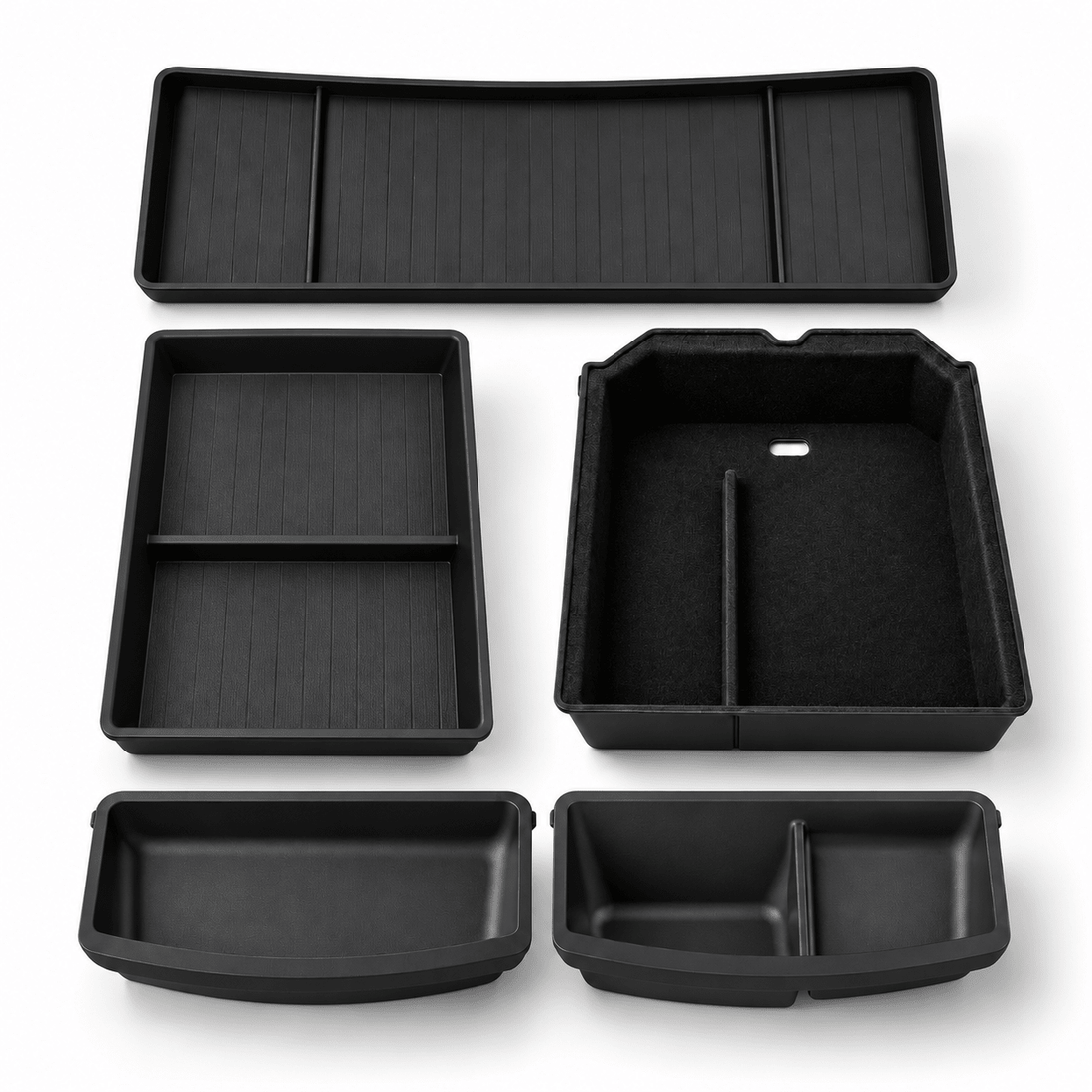 Five black storage pieces arranged on white: two console organizers, a long behind-screen tray and two shaped under-seat trays.