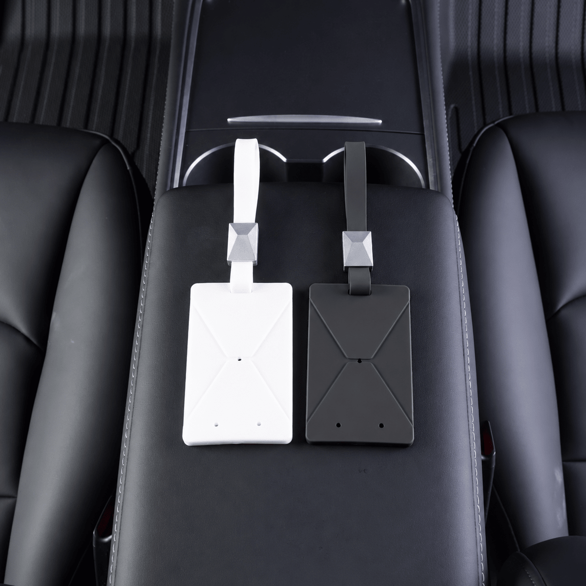 White and black key-card sleeves resting side by side on a center armrest.