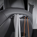 Tesla Model 3/Y seat-back organizer with open hooks holding a gray scarf and brown bag straps.