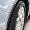 Black protector strip following the edge of a silver car's wheel arch